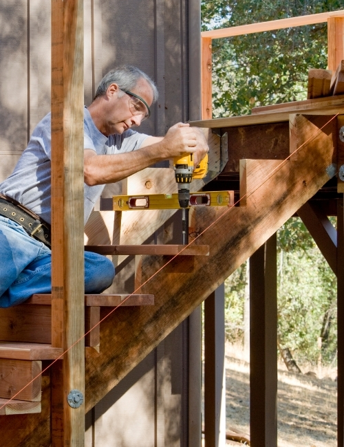 Man installing rails on deck stairs