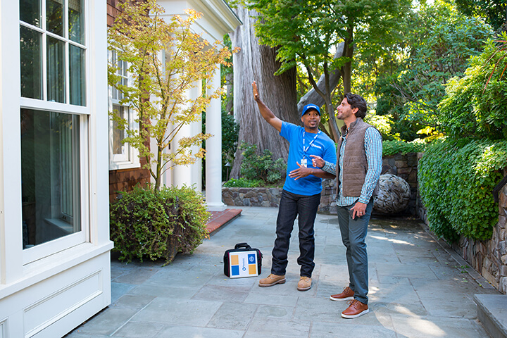 handyman from Handyman Connection inspecting outdoor patio with homeowner present