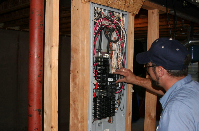 electrical repair handyman working on fuse box in Greenwood, IN, area home