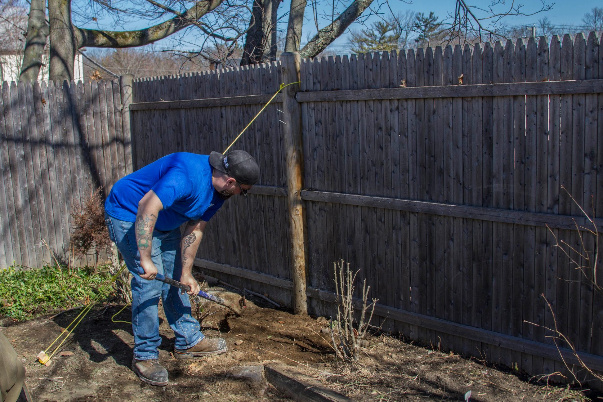handyman installing a wooden fence post in Greenfield, IN