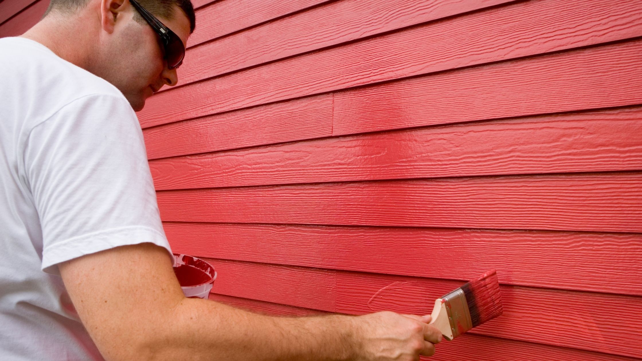 man painting exterior of home