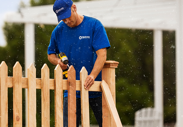 handyman installing new wooden fence