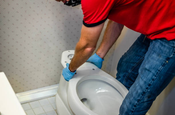 handyman plumber installing new toilet in Lakewood home