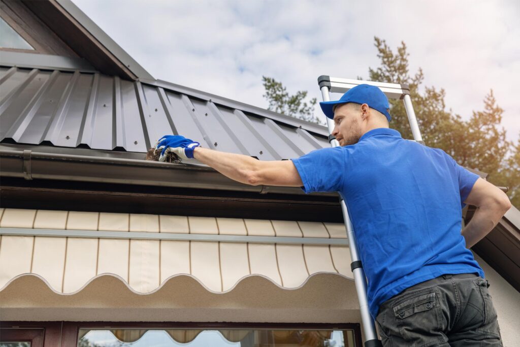 Evergreen handyman cleaning home's gutters