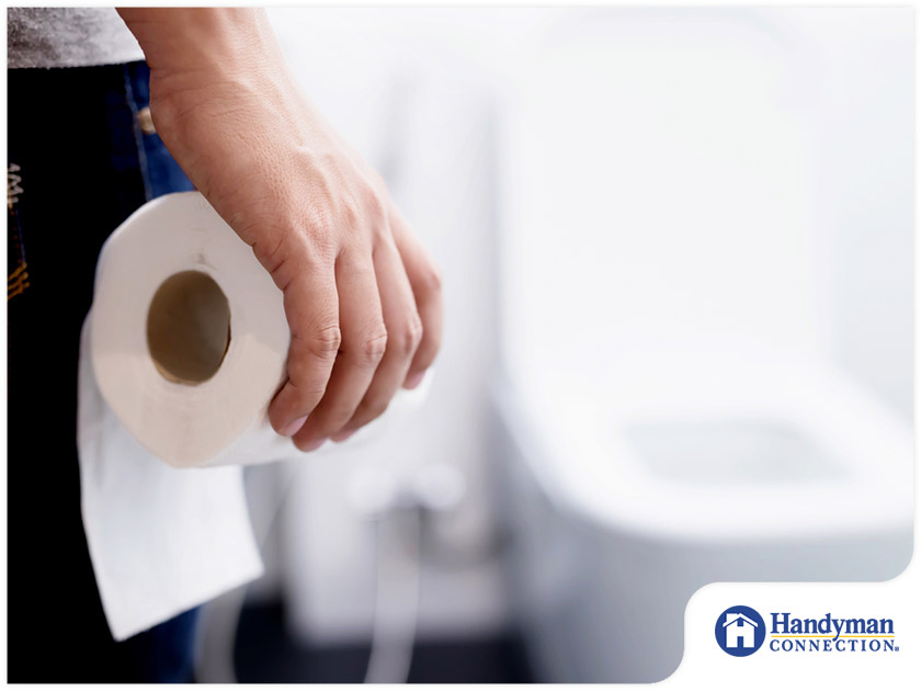 person holding roll of toilet paper bathroom
