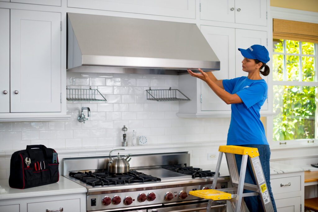 handyperson installing new kitchen hood