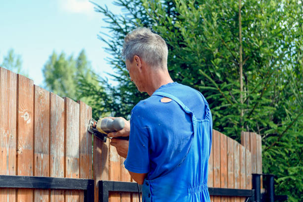 fence handyman using jigsaw to cut fence boards