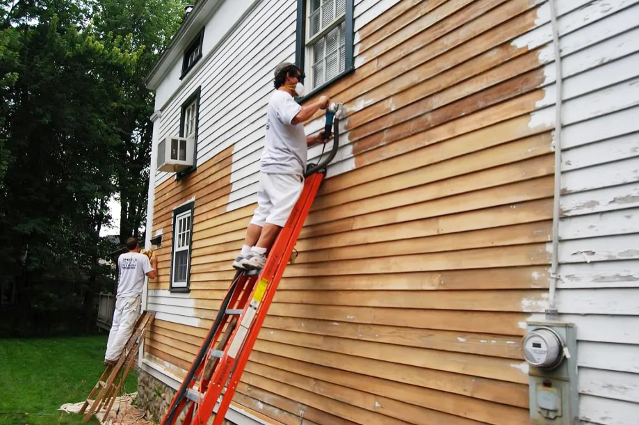 two handymen painting the exterior of a home white