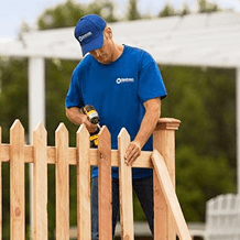 handyman installing wooden fence pickets