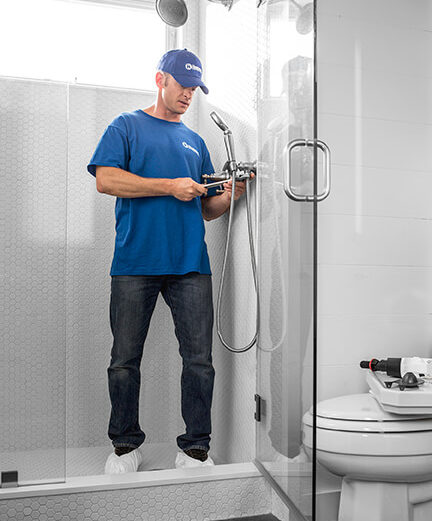 handyman installing bathroom shower fixtures