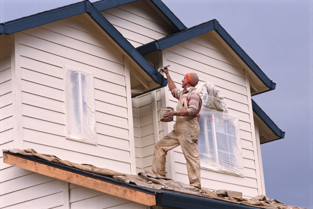 handyman from Handyman Connection painting the exterior of a home