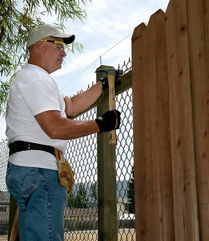 handyman in Plymouth, MA, installing new wooden fence pickets