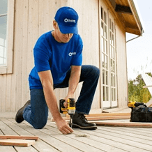 handyman using power drill to install deck boards