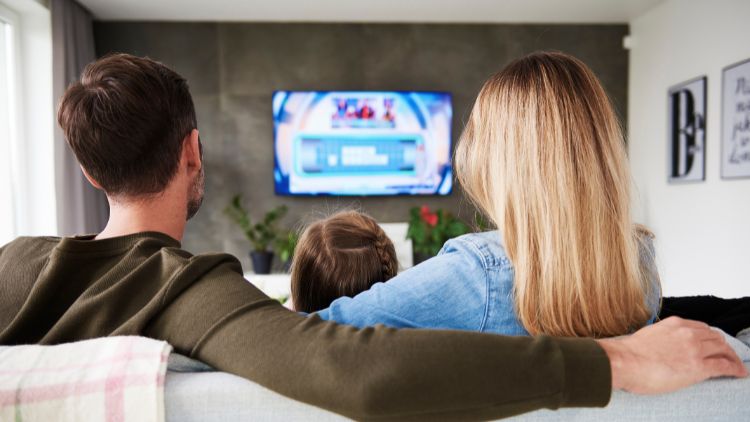 Family watching tv in living room