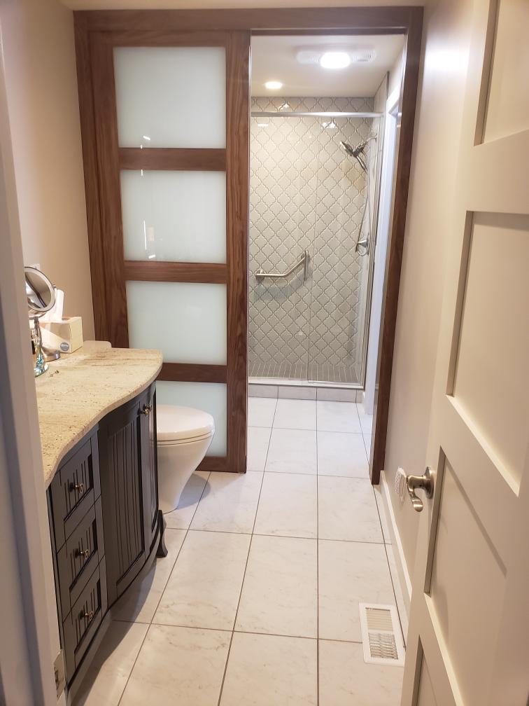 bathroom remodel done by our craftsmen for a homeowner in Roswell, GA. This included new tile flooring and a shower door installed