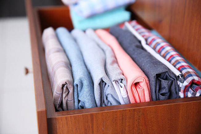 https://handymanconnection.com/wp-content/uploads/2021/05/bigstock-Neatly-folded-clothes-in-woode-127062611.jpg